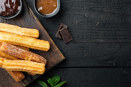 传统的西班牙甜点 churros 配糖和巧克力 在黑色木桌背景上 顶视图平躺着 有文字空间 复制空间焦糖烹饪文化美食早餐食物面包图片