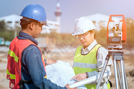 建筑工程师和工头工人在现场检查新基础设施建设项目的施工图图片