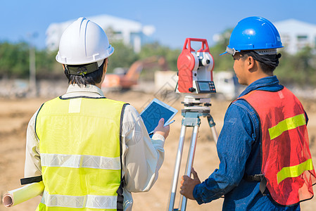 建筑工程师持有施工图和智能平板电脑 工头检查施工现场图片