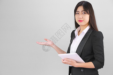 穿着西装的 Asain 女性站着使用数字平板电脑和手指办公室长发女士女孩工作室商务工具软垫学生药片图片