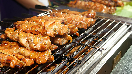 端着烤街上烤肉串 泰国传统街头咖啡馆的烤肉串上烤着一组美味的肉串背景