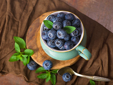 新鲜的蓝莓和薄荷叶小吃水果木头薄荷桌子蓝色营养奶油叶子食物图片