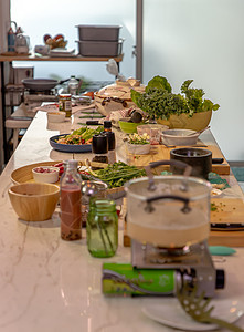 一个厨房 在房间的中央放着一张餐桌 餐桌上摆满了做饭的食材食品桌子香料烹饪家庭盘子项目职业食谱草本植物图片
