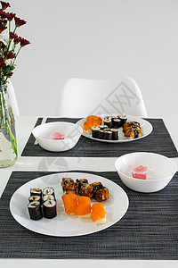 新鲜寿司和鲜寿司卷在白色盘子上 寿司午餐饮食餐厅午餐美味烹饪桌子海鲜送货花瓶服务图片