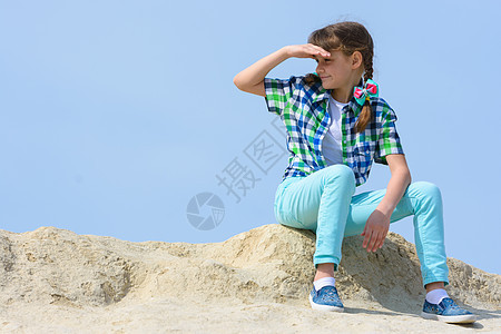 女孩坐在山顶的山顶上 望着距离图片