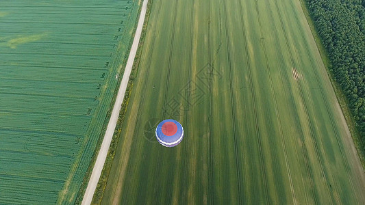 天空中的热气球在田野上运输乐趣天线飞艇航班蓝色篮子闲暇旅行航空图片