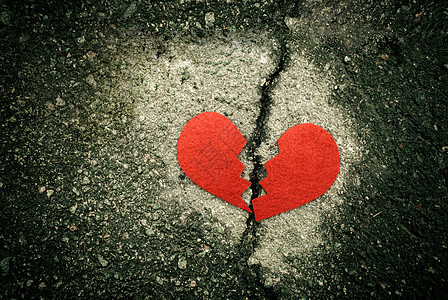 在破裂的沥青的破碎的红色心脏 离婚概念图片