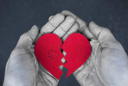破碎的心在手中-离婚的概念 与红色的心的单色照片 布拉克和惠特图片