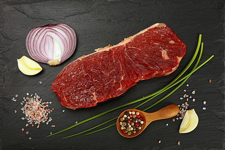 黑板上的牛肉牛排肉和香料牛扒洋葱营养美食胡椒子香葱牛肉石板食物调味品图片