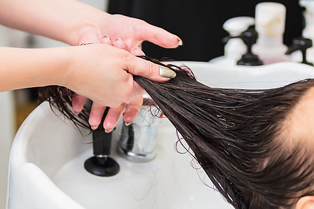 理发师洗了一个头发长在水槽里的女孩的头发型师按摩护理客户温泉润肤专家理发治疗造型图片