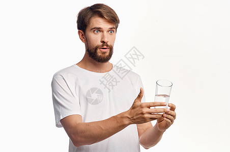 带着一杯水的欢乐男人 白白色T恤短袖圆领衫 轻背景生活方式 用手抚摸饮食矿物饮料营养口渴玻璃液体工作室手指生活图片
