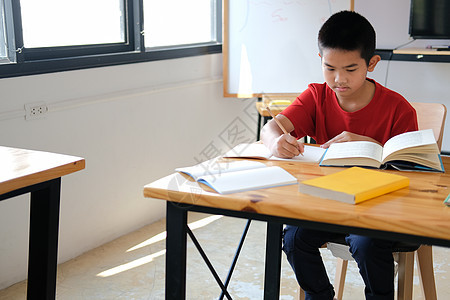 学习写作笔记做功课的男孩学生 在学校进行学习教育图片