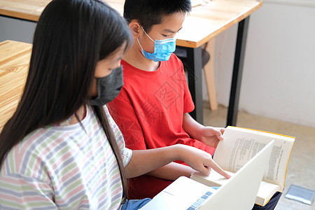 戴着面罩的男孩女孩学生在网上学习课程 在家远程会议远程教育口罩面具视频女学生隔离瞳孔男生家庭作业学校班级背景图片