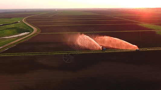 空中观察 灌溉系统为农田浇水生长日落洒水器管道拖拉机工业地面农业农村农场图片