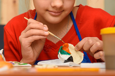 一个女孩用水彩画一个盐面纸的手工艺品图片