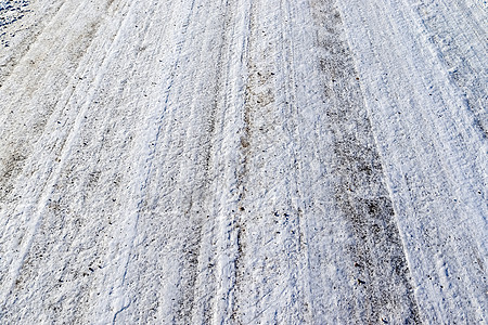 近距离观察积雪覆盖的街道上的轮胎痕迹季节摄影胎迹阳光天气冒险曲目旅行阴影车轮图片