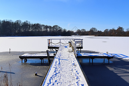 在德国阳光明媚的一天 雪在冰冻湖边覆盖了木制码头海岸金字塔探索冷冻天空旅行风景假期场景木头图片