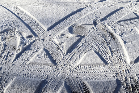 近距离观察积雪覆盖的街道上的轮胎痕迹小路蓝色牵引力车轮阳光摄影天气季节旅行曲线图片