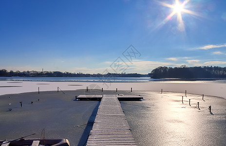 在德国阳光明媚的一天 雪在冰冻湖边覆盖了木制码头探索新雪蓝色木头天空旅游公园冷冻金字塔风景图片