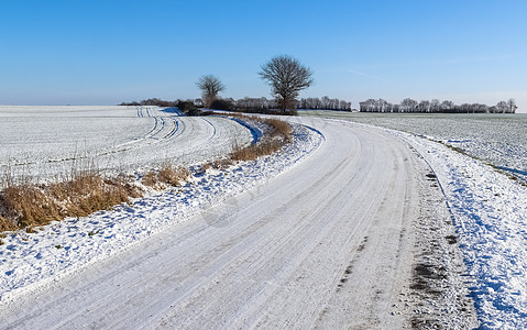 在德国阳光明媚的一天 乡下公路被雪淹没旅行蓝色全景季节太阳场景地平线假期沥青风景图片