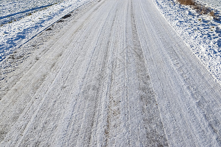 近距离观察积雪覆盖的街道上的轮胎痕迹季节蓝色雪堆摄影小路粉雪冒险车轮阴影胎迹图片