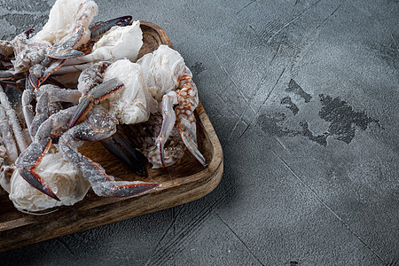 用木盘 灰色背景 复制空间和文字空间冷冻生蓝色游泳蟹肉 用木质餐具背景图片
