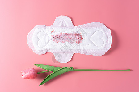 用过的卫生巾 粉红色背景上带郁金香花的卫生巾 月经 女性卫生 顶视图图片