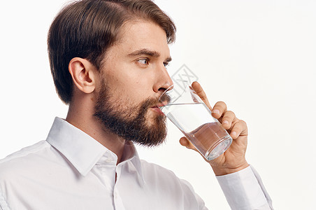 一个喝杯水饮料的人的肖像 冷却淡光背景衬衫模型男性液体饮食手指玻璃工作室营养生活矿物男人图片