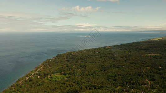 热带岛屿的海岸线 菲律宾卡米甘岛海滩棕榈岩石悬崖森林风景情调爬坡树林海景图片