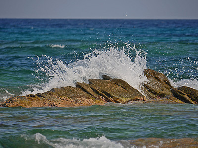 冲向岩石的波浪天空蓝色海浪支撑飞溅海滩海岸线晴天海景旅游图片