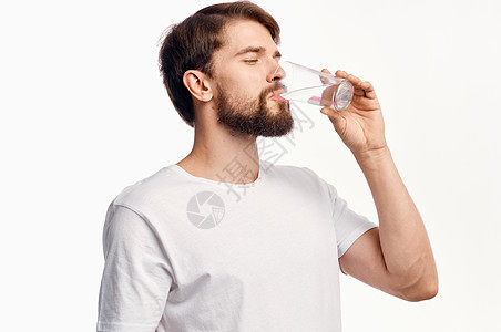 长得帅的帅哥 在白色T恤短袖圆形风景上 喝着一杯水男人饮料工作室手指营养生活饮食矿物玻璃口渴图片