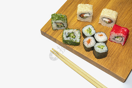 白背景的木板上的寿司和棍子图片