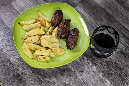 土豆香肠和一杯葡萄酒小吃熏肉土豆盘子桌子餐巾迷迭香糊状物美食餐厅图片