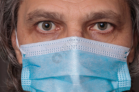 戴医疗面具的成年男子 近视眼神 手握针刺医生眼睛安全卫生治愈危险蓝色手术保健白色图片