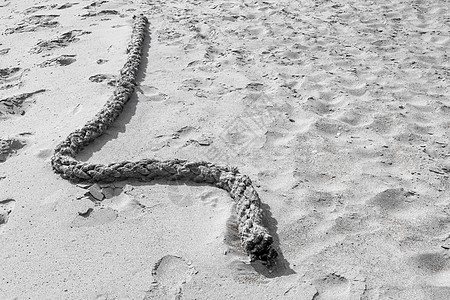 躺在沙滩沙丘上的一根绳子图片