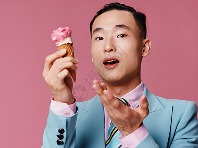 带冰淇淋的快乐男人 粉红色背景和蓝色外套领带粉色衬衫图片