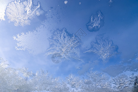 在一个非常寒冷的冬日 窗户上美丽的冰花季节薄片玻璃磨砂雪花蓝色水晶石头天空宏观图片