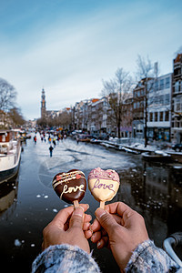 喜欢浪漫的冰淇淋 背景是人们在阿姆斯特丹结冰的运河滑冰 情人节浪漫概念城市首都溜冰者气候食物奶油天气旅游季节乐趣图片