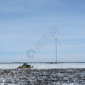 蓝天下方块状地的杜特奇草原上的雪田和拖拉机图片