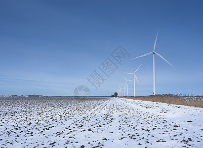 蓝天下方圆地的杜特奇产雪田和风力涡轮机发电机技术地平线翅膀阳光风能力量环境活力农场图片