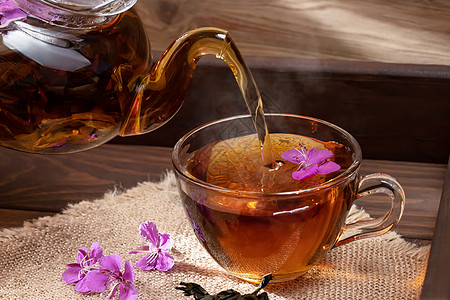将香草药茶倒入明亮的杯中柳草饮料疗法茶壶酿造植物杯子草本植物树叶照片图片
