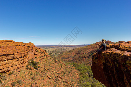 坐在澳大利亚北区Watarrka国家公园悬崖边缘的峡谷旁 青年男子对峡谷视而不见图片