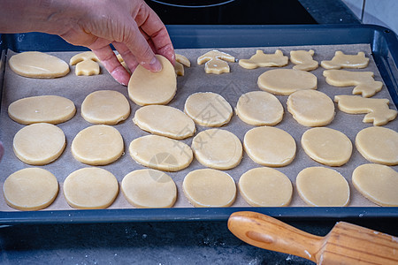 女人在家厨房做黄油曲奇饼的馅饼糕点木板蛋糕面包师桌子面包滚动烹饪食物图片