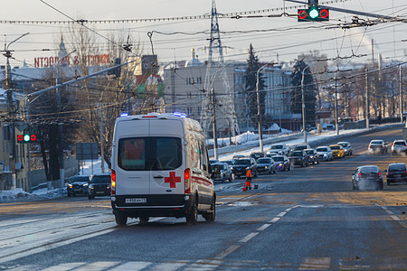 白色救护车小客车在冬季湿街道上行驶服务社论救援汽车情况交通生活护理人员药品城市图片