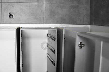 不锈钢伸缩卡口式抽屉滑轨 安装在灰色刨花板制成的厨柜上 用于家具制造的木工配件 定制厨房安装螺丝刀木板架子内阁建造贮存材料橱柜导图片