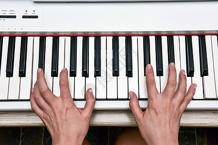女人的手在家里弹电子数码钢琴 这位女士是专业钢琴家 使用钢琴电子键盘编曲 练习键盘作曲的音乐家琴键床单笔记艺术家韵律女性按钮娱乐图片
