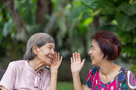 女儿与听力障碍的老年妇女交谈;图片