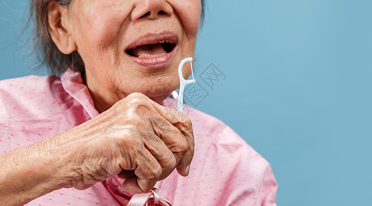 护理员在使用牙科霜棒时照顾年长的老年妇女牙线女士牙线棒牙刷退休照顾者口腔卫生奶奶保健图片