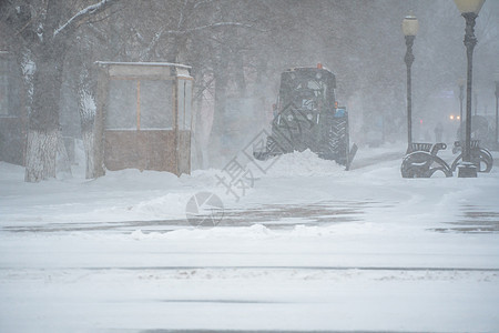 除雪设备 公用事业和市政服务正在清除暴风雪 暴风雪和暴风雪中街道上的积雪 冬天的天气状况 下雪的恶劣天气状况车辆体力劳动者装载机图片