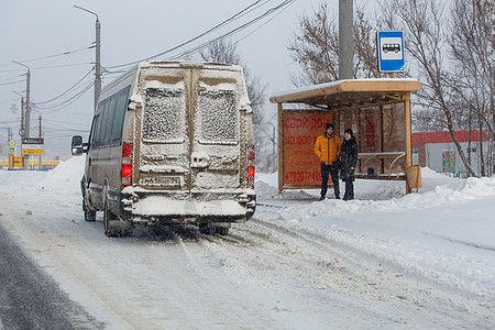 在俄罗斯图拉岛冬季雪天 在公共汽车站等待交通的男男女女橙子骑术社论运输小巴降雪汽车紧迫感街道城市图片